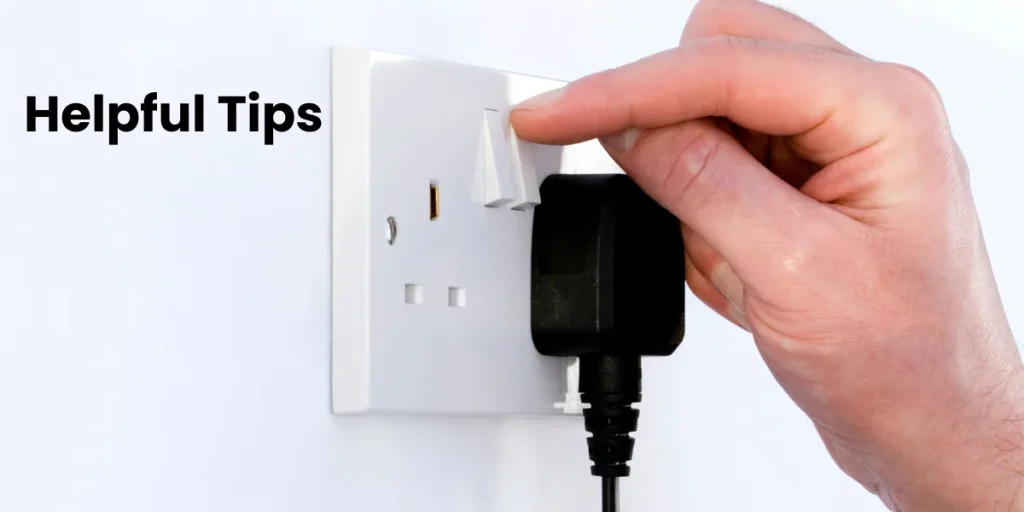 Tips to Reduce Your FESCO Electricity Bill Hand plugging a device into a wall socket, symbolizing electricity usage and energy saving tips.